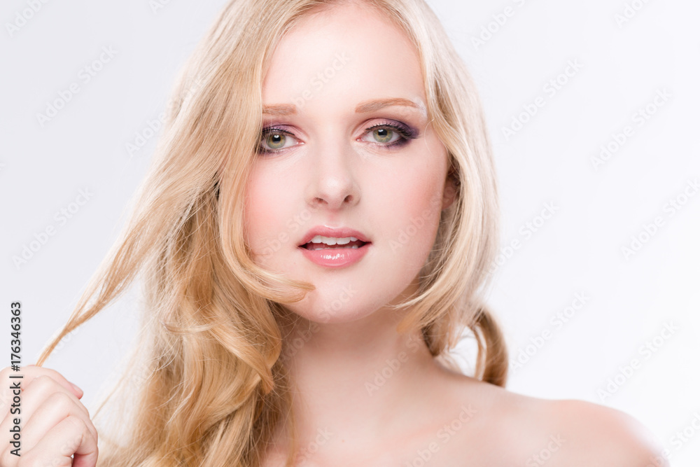 hübsche blonde Frau zieht sich an einer Haarsträhne vor neutralem Hintergrund hübsche blonde Frau zieht sich an einer Haarsträhne vor neutralem Hintergrund