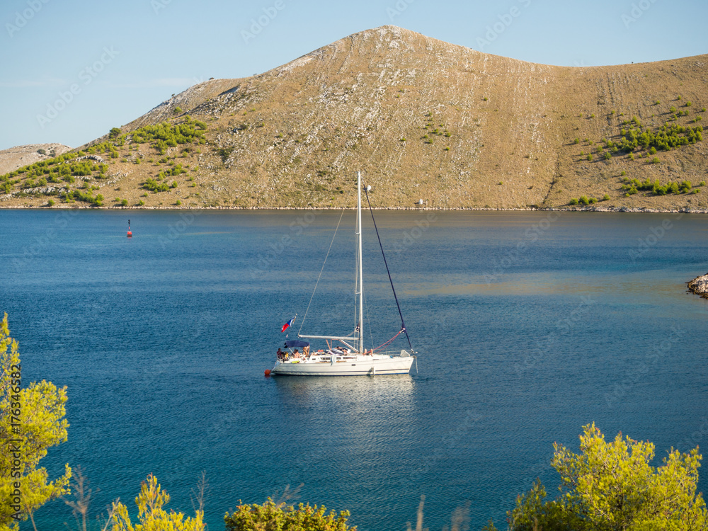 Sailing yacht in Croatia, anchoring in a bay, windy summer on the boat between rocky islands of the Mediterranean sea