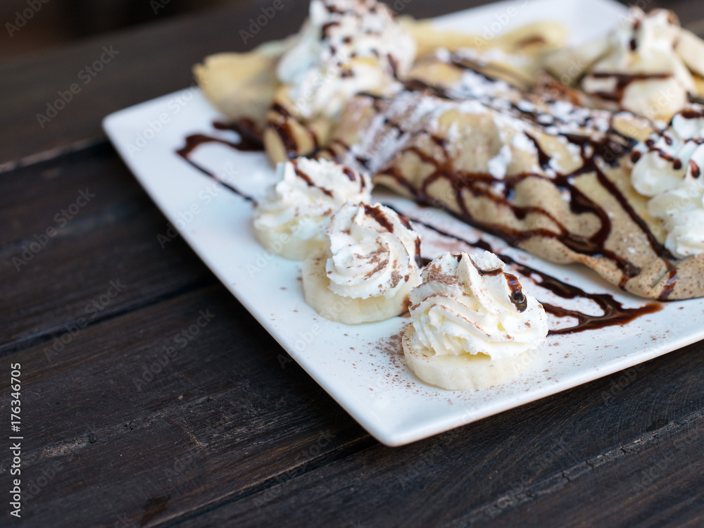 Pancakes with banana and whipped cream.