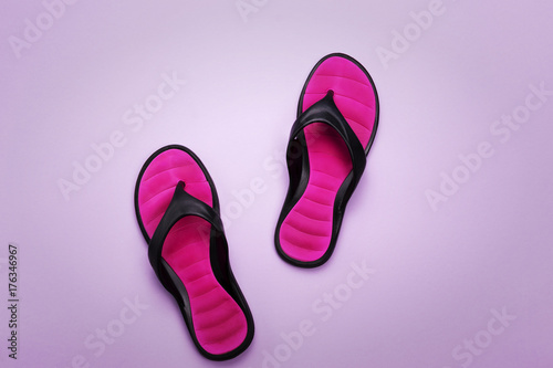 Pink flip flops on purple background