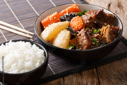 Korean stewed beef short ribs with vegetables and rice garnish close-up. horizontal