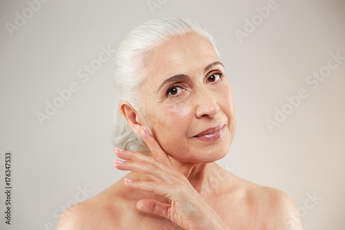 Naked elderly woman posing isolated