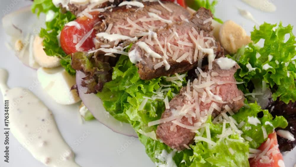 Salad with meat, close-up view, sliced grilled beef steak with parmesan cheese, tomatoes, eggs and sauce, Restaurant food, loop, 4K, ProRes codec, 422 HQ Salad with meat, close-up view, sliced grilled beef steak with parmesan cheese, tomatoes, eggs and sauce, Restaurant food, loop, 4K, ProRes codec, 422 HQ