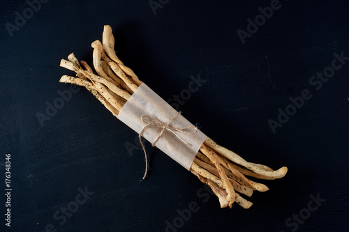 Traditional Italian snack, bread - grissini. On a dark stone table. photo