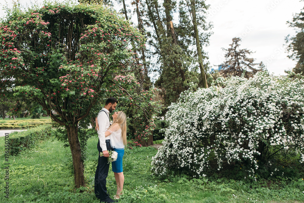 Young, beautiful bride and groom walking along in the park Young, beautiful bride and groom walking along in the park