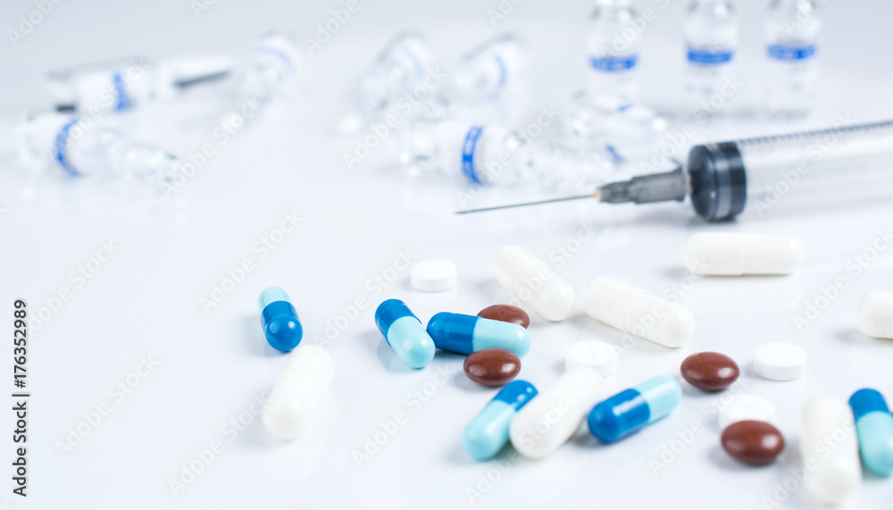 Pharmaceutical medical colorful pills, capsules, ampoules and syringe on white background Pharmaceutical medical colorful pills, capsules, ampoules and syringe on white background