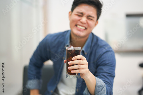 close up asian man holding glass of cola water while laughing with good feeling,happy concept
