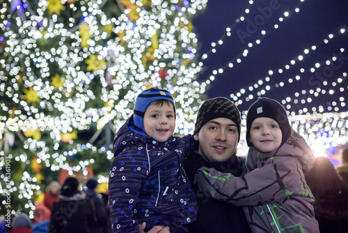 family, childhood, season and people concept - happy in winter clothes over snowy city background photo