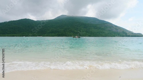Greeh hilly tropical island with clear blue sea water and beach sand