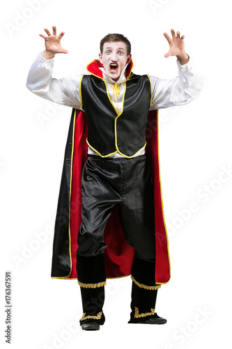halloween, celebrating, masquerade concept. on white background isolated figure of young guy that dressed in silk costume of famous character count dracula. he is making face of anger