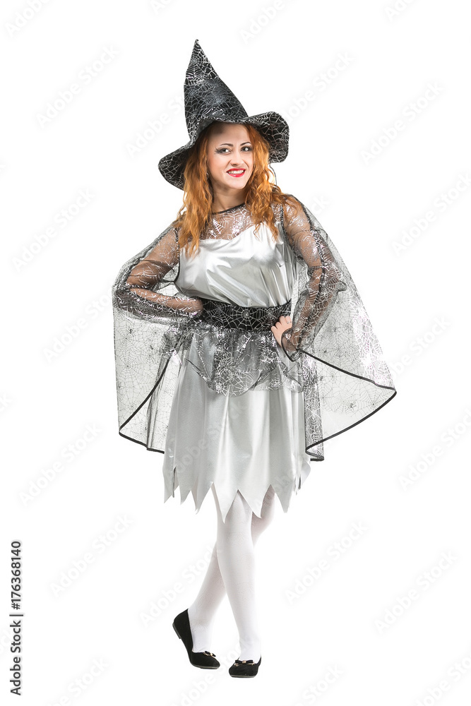 halloween, mystic, holidays concept. isoalted red haired charming witch wearing pointy hat, silver dress with light shawl decorated with shining web and black shoes on white background halloween, mystic, holidays concept. isoalted red haired charming witch wearing pointy hat, silver dress with light shawl decorated with shining web and black shoes on white background