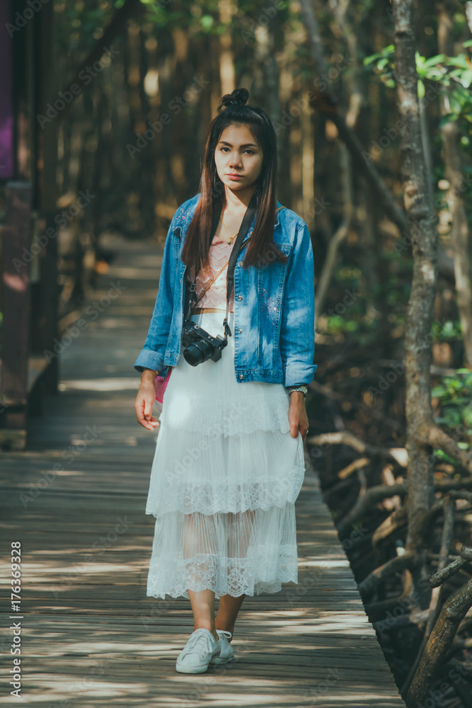 women Asian hipster take a photo in deep forest in Thailand. Travel Concept.