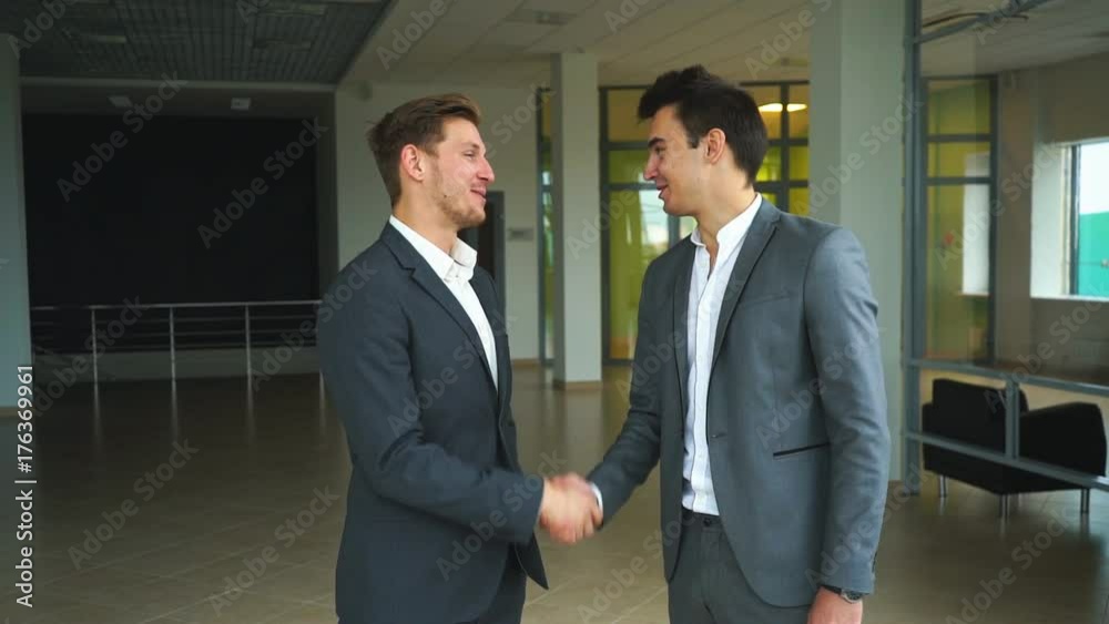 two businessmen met in the office and shake hands two businessmen met in the office and shake hands