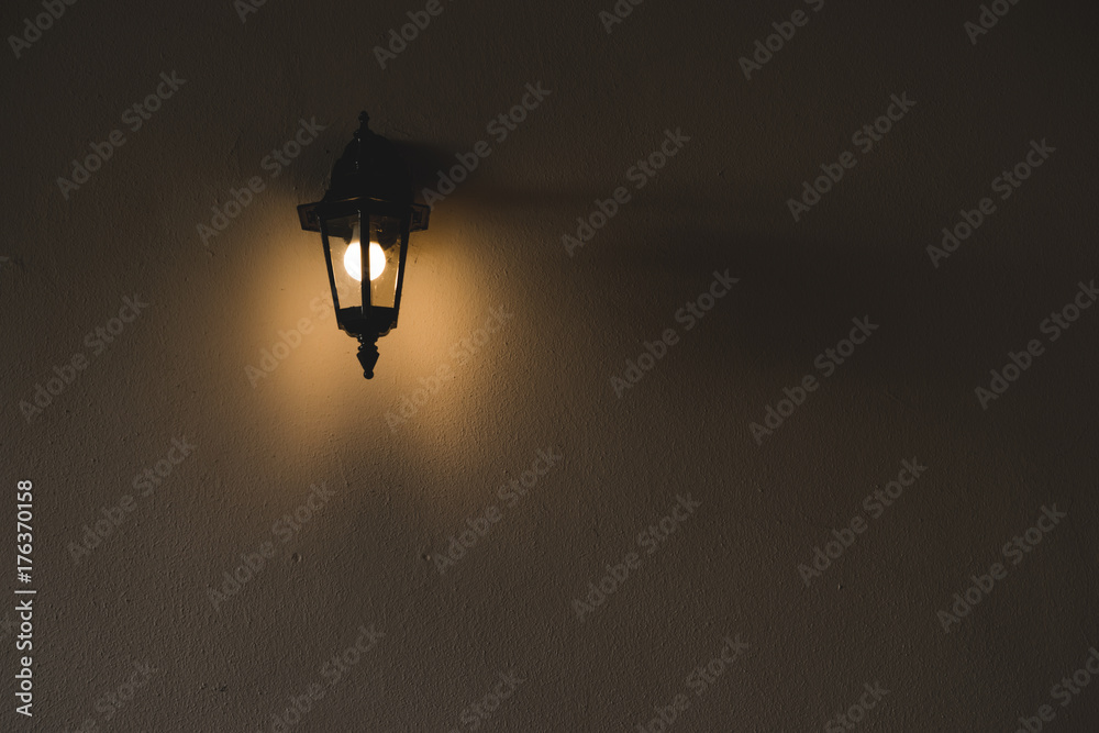 Φωτογραφία Lamp sconce on a wall in darkness