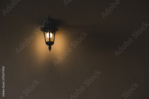 Slika na platnu Lamp sconce on a wall in darkness