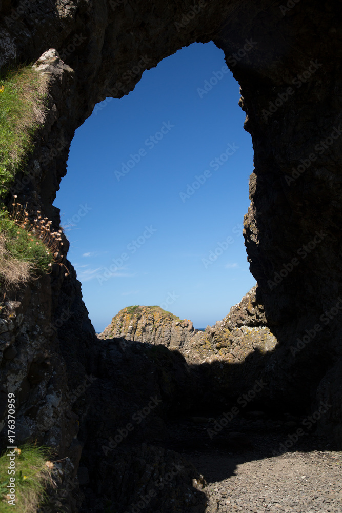 Unique rock formation, cave and blue sky, Antrim coast, North Ireland
