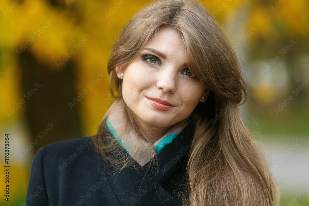 Beautiful elegant woman standing in a park in autumn Beautiful elegant woman standing in a park in autumn