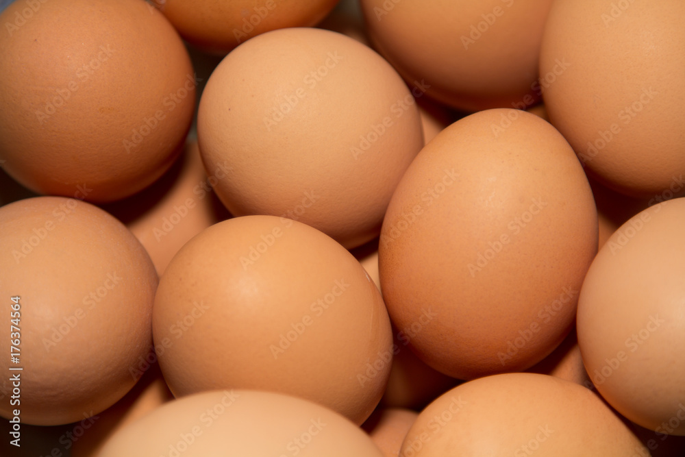 Multiple brown eggs, uncooked, closeup shot,  repetive shapes. 