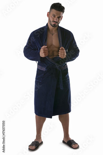 Handsome muscular male in bathrobe or nightrobe undressing, isolated on white background.