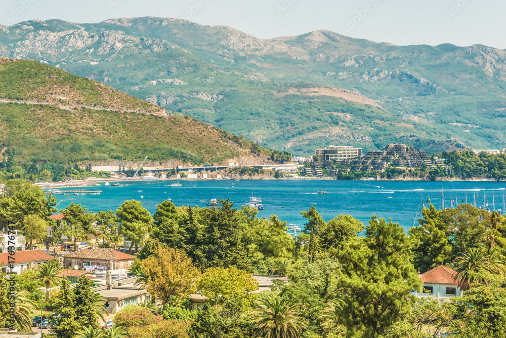 Sea view from the mountain. Fragment of the embankment of the Gulf of the Adriatic Sea in Budva, Montenegro, where the most popular beaches are located on the Budva Riviera.
