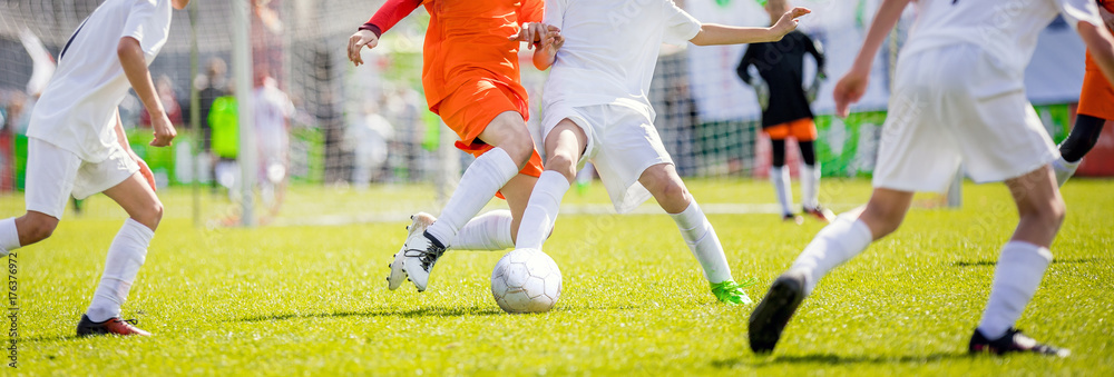 Fototapeta premium Children's soccer drills. Kids kicking football match on pitch. College soccer class. Running soccer players. Sport education.