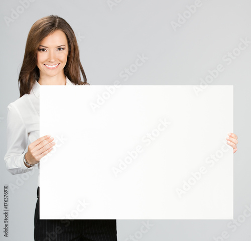 Businesswoman showing signboard, over grey