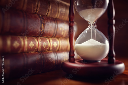 Old books and hourglass in library