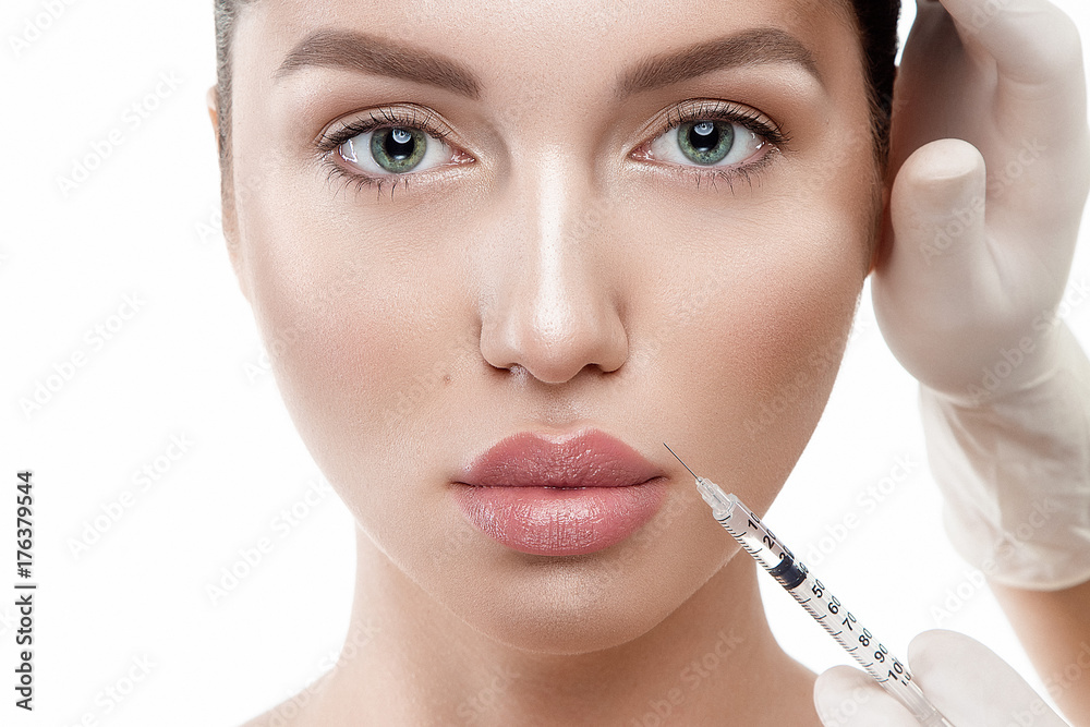 Beauty woman portrait close up on white background with hands in medical gloves on face making injection. Beauty woman portrait close up on white background with hands in medical gloves on face making injection.