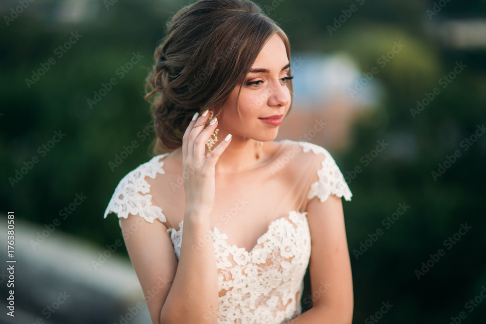 Young girl in wedding dress on city background at sunset. Summer Young girl in wedding dress on city background at sunset. Summer