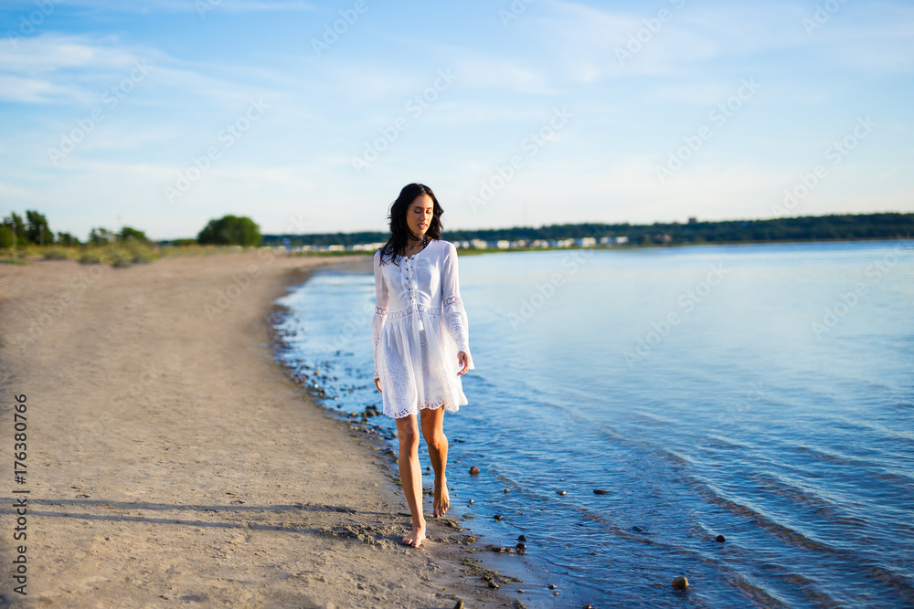 young beautiful woman in white dress walking on the beach young beautiful woman in white dress walking on the beach