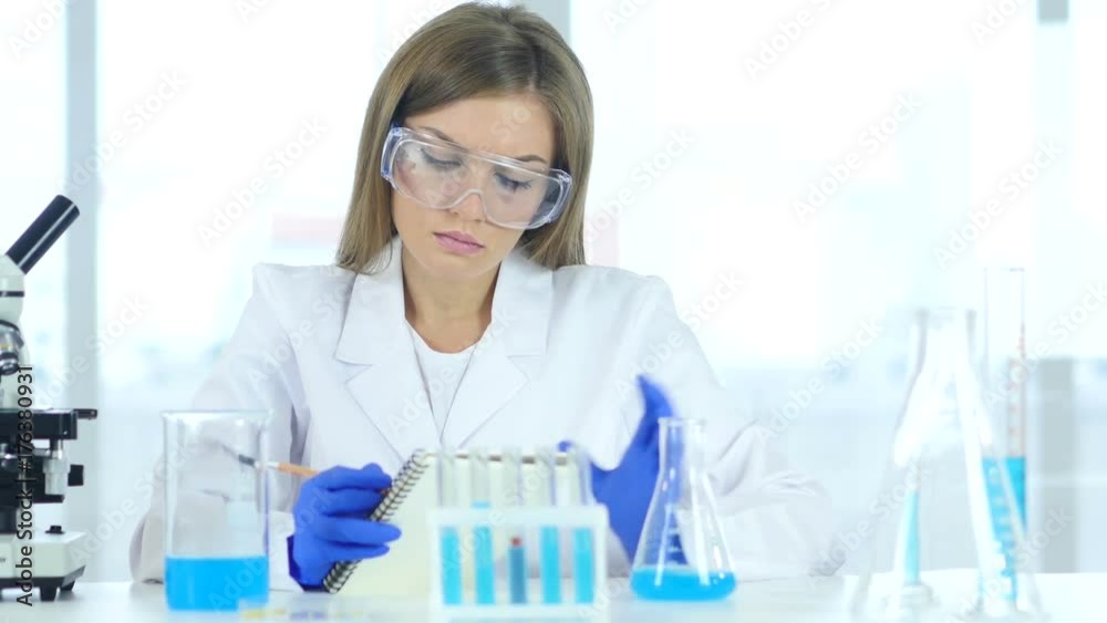 Female Scientist Writing Details, Result of Research in Laboratory Female Scientist Writing Details, Result of Research in Laboratory