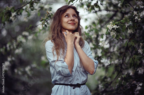 young adult girl enjoys smell of spring flowers apple