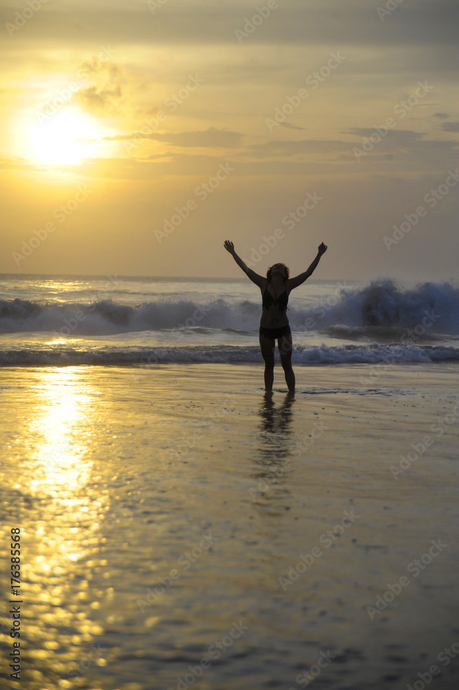 young woman on sea landscape sunset horizon with amazing sun and dramatic orange sky