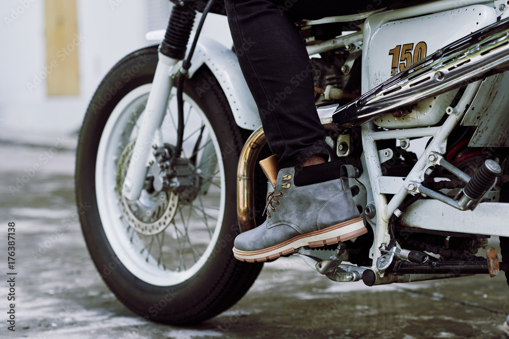 Fototapeta premium Close-up shot of male foot pressing gas pedal on vintage motorcycle, close-up shot
