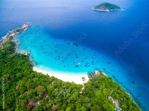 Fototapeta Naklejka Na Ścianę i Meble -  Top aerial view of isolated beautiful tropical island with white sand beach, blue clear water and granite stones. Also top view of speedboats above coral reef. Similan Islands, Thailand.