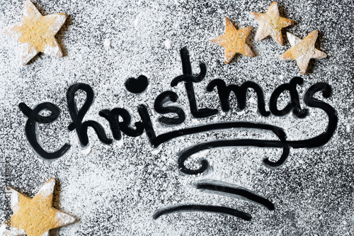 Christmas Baking Word Written in Flour or Powdered Sugar Surrounded with Gingerbread Star Shaped Cookies Sign Concept