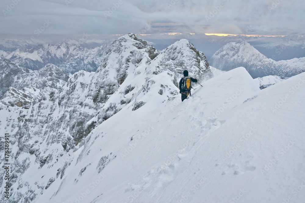 Bergsteiger klettert den Jubiläumsgrat im Winter bei Schnee von der Zugspitze zur Alpspitze