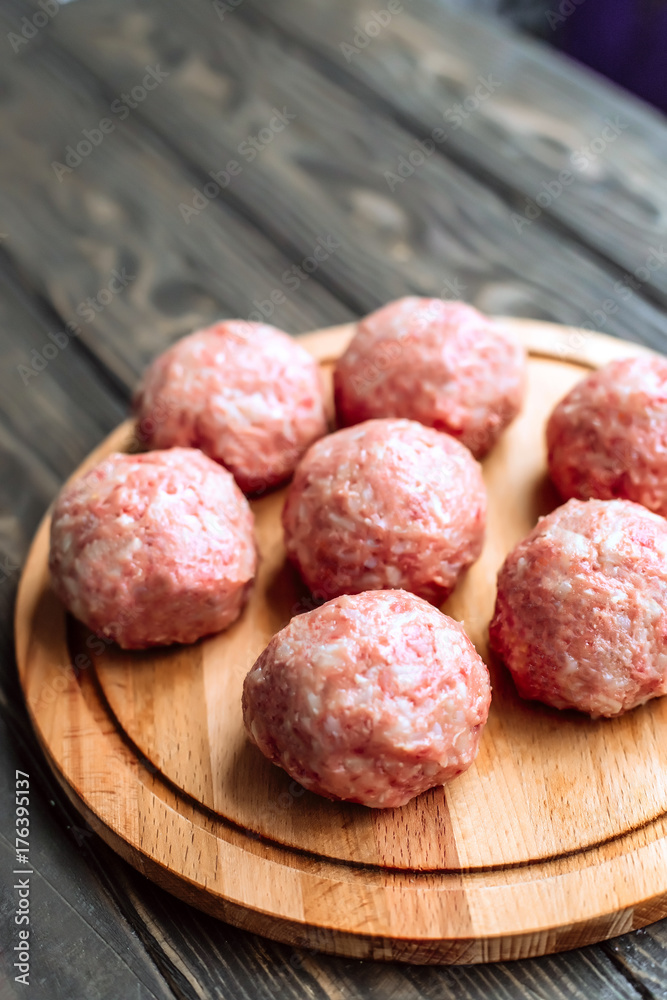 Raw cutlets on a wooden background