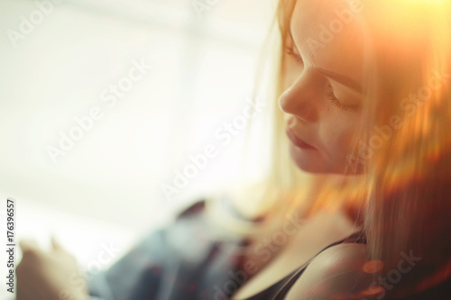 portrait of a beautiful young blonde woman with sun rays and glare