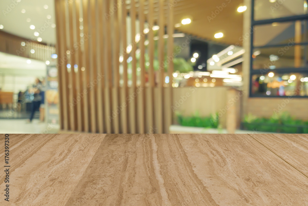 Empty wooden table in front of blurred background of restaurant.