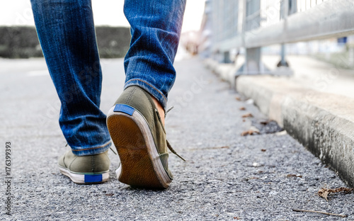 Woman wear jeans and sneaker shoes walk on the road