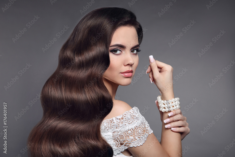 Beautiful hair. Brunette girl portrait. Beauty makeup. Long healthy wavy  hair. Fashion pearl jewelry. Manicured nails. Elegant lady isolated on gray  studio background. Stock Photo | Adobe Stock