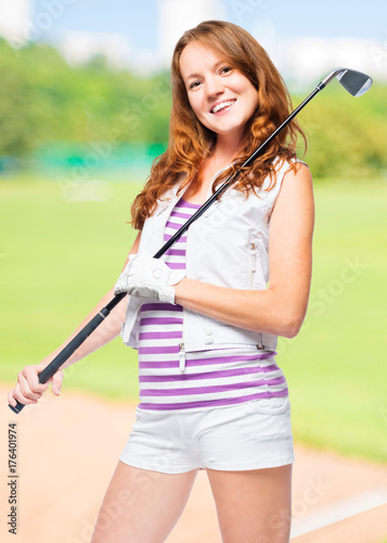 Vertical portrait of a golf player with a golf club on a background of golf courses © kosmos111