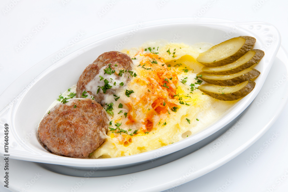 simple dish of Russian, Belarusian, Ukrainian cuisine on a white background Cutlets with potatoes and pickled cucumbers..