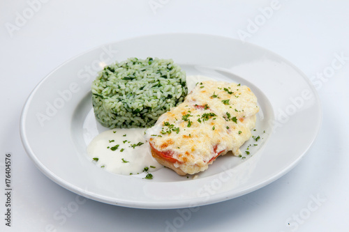 simple dish of Russian, Belarusian, Ukrainian cuisine on a white background chicken with cheese and rice and greens.