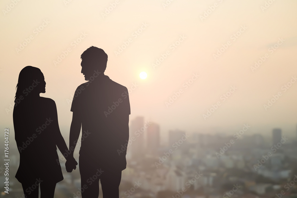 black silhouette of couples lover holding hand and looking each other on blurred beautiful sunset sky city downtown,honeymoon concept