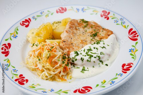 simple dish of Russian, Belarusian, Ukrainian cuisine on a white background Cutlets with potatoes and pickled cucumbers..