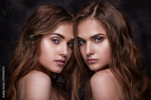 Fashion studio picture of two twins beautiful women. Close-up be