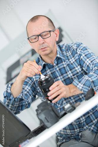 Man dusting camera lens
