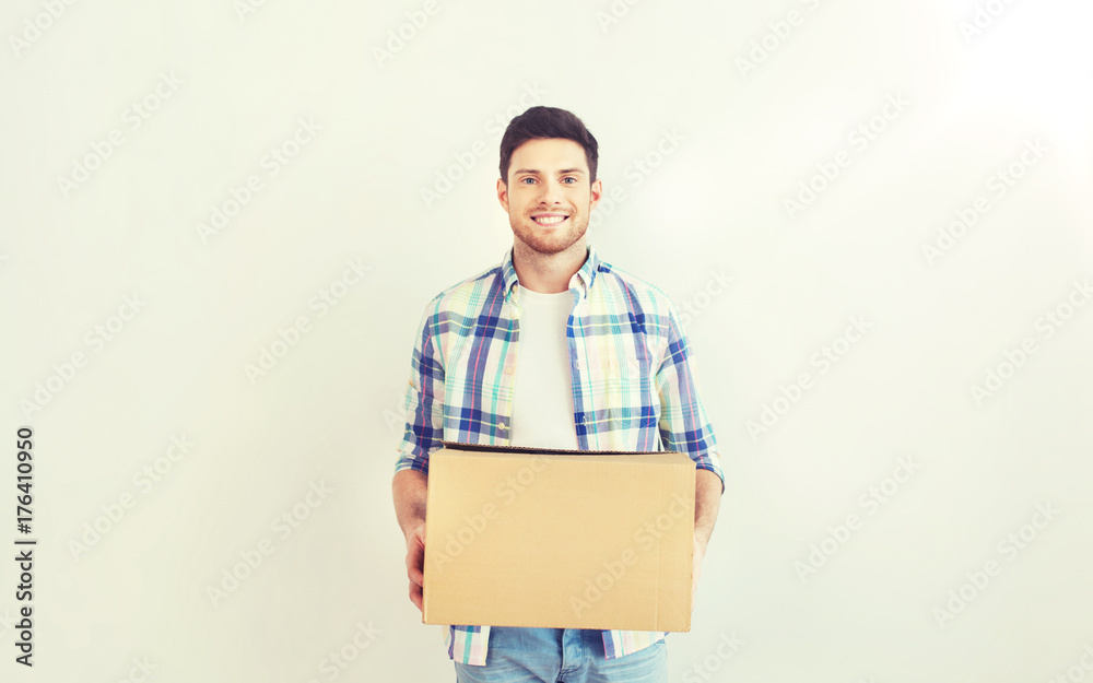 smiling young man with cardboard box at home smiling young man with cardboard box at home